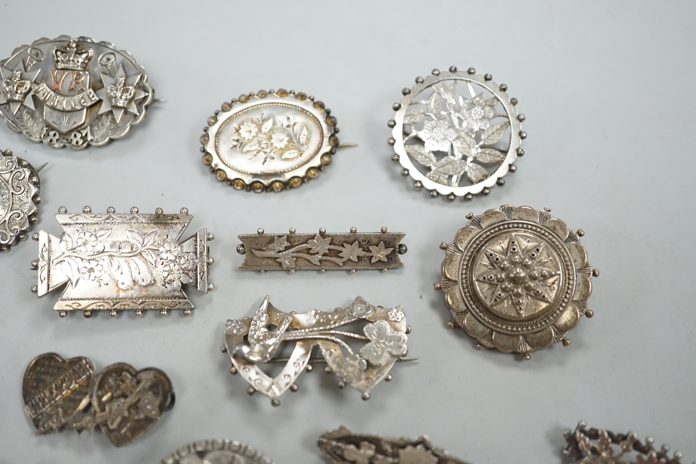 A small collection of twenty nine assorted Victorian and later silver or white metal brooches.